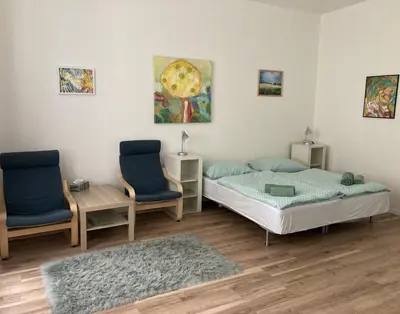 a bedroom with two beds and two chairs at Enter City Center in Prague