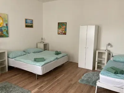 a bedroom with two beds and a white cabinet at Enter City Center in Prague