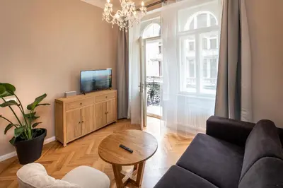 a living room with a couch and a tv and a table at Downtown - Apart Hotel Zborovska in Prague