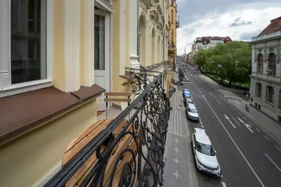 a balcony of a building with cars parked on the street at Downtown - Apart Hotel Zborovska in Prague