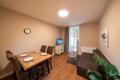 a dining room with a table and chairs and a clock at Downtown - Apart Hotel Zborovska in Prague