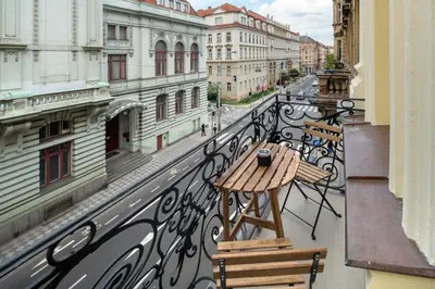 a balcony with a table and benches on a city street at Downtown - Apart Hotel Zborovska in Prague
