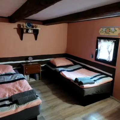 a bedroom with two beds and a tv on the wall at Apartmán Roubenka na Dobřeni in Mělník