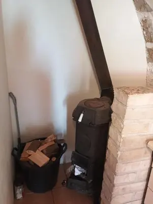 a wood stove in a room with a trash can at Apartmán Roubenka na Dobřeni in Mělník