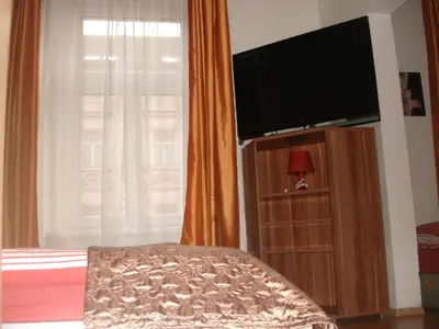 a bedroom with a bed and a flat screen tv at EASY JOURNEY Apartments in Prague