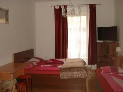 a bedroom with a bed and a window with red curtains at EASY JOURNEY Apartments in Prague
