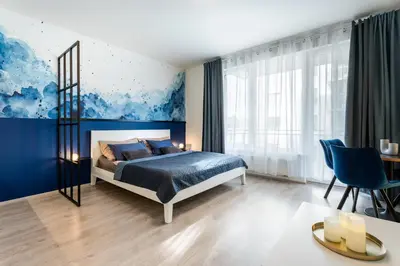 a bedroom with a bed and a blue wall at AuriApartments Libeň nový byt 1kk s garáží in Prague