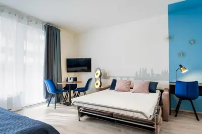 a bedroom with a bed and a table and chairs at AuriApartments Libeň nový byt 1kk s garáží in Prague