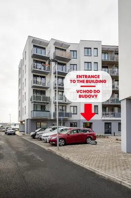 a sign in a parking lot next to a building at AuriApartments Libeň nový byt 1kk s garáží in Prague