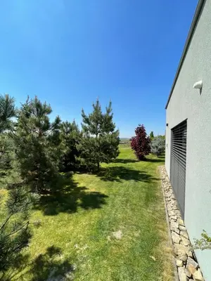 a yard with trees next to a building at Ubytování U Vinice in Mělník