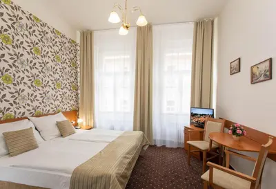 a hotel room with a bed and a table and a desk at Novoměstský hotel in Prague