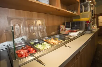 a kitchen counter with two sinks and some vegetables at Novoměstský hotel in Prague