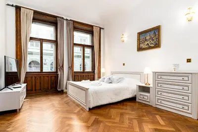 a bedroom with a white bed and a wooden floor at Magnificent King Suite in Prague