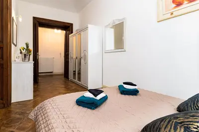 a bedroom with a bed with two blue pillows on it at Magnificent King Suite in Prague