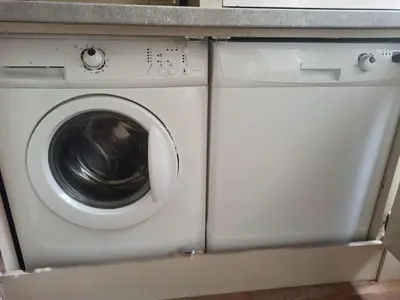 a white washing machine sitting under a counter at Magnificent King Suite in Prague