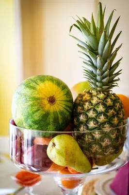 a bowl of fruit with a pineapple and pears at Magnificent King Suite in Prague