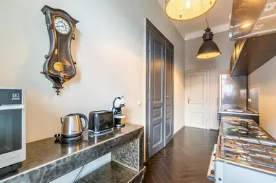 a kitchen with a clock on the wall at Masná - Old Town Grand Residence in Prague