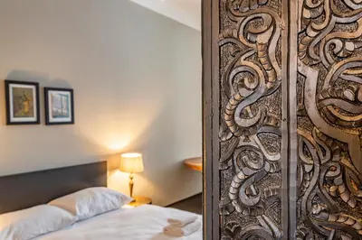 a bedroom with a wooden door with a bed in it at Masná - Old Town Grand Residence in Prague