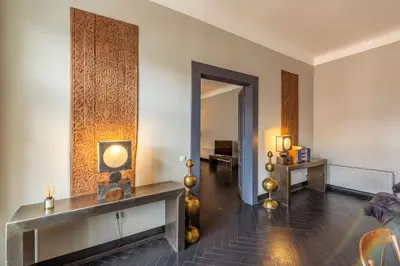 a living room with a table and a mirror at Masná - Old Town Grand Residence in Prague