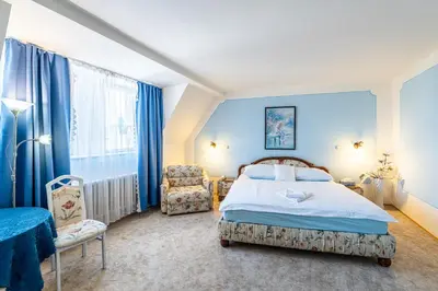 a bedroom with a bed and a chair in it at Hotel Trumf in Mladá Boleslav