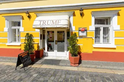 a yellow and red building with a entrance to a store at Hotel Trumf in Mladá Boleslav