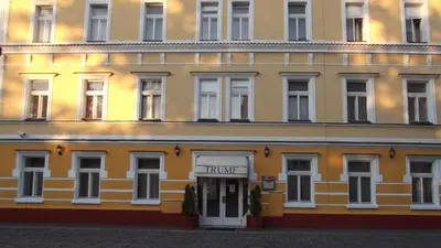 a large yellow building with a sign for a hotel at Hotel Trumf in Mladá Boleslav