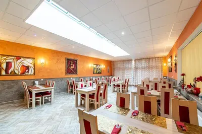 a dining room with wooden tables and chairs at Hotel Trumf in Mladá Boleslav
