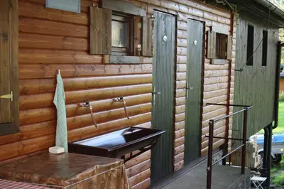a bathroom with a sink and a wooden wall at Letní rekreační středisko Schiffler Miroslav in Samopše