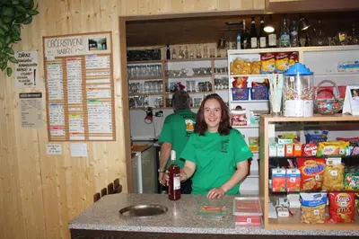 a woman standing behind a counter in a kitchen at Letní rekreační středisko Schiffler Miroslav in Samopše