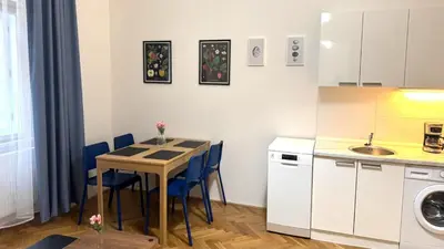 a small kitchen with a table and blue chairs at Side Street Apartments in Prague