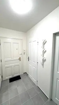 a hallway with white doors and a tile floor at Side Street Apartments in Prague
