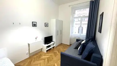 a living room with a blue couch and a television at Side Street Apartments in Prague