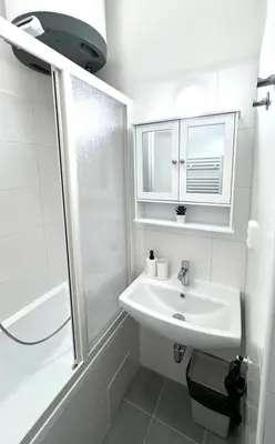 a white bathroom with a sink and a shower at Side Street Apartments in Prague