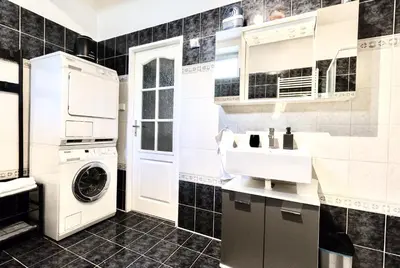 a black and white kitchen with a washer and dryer at Apartmán u Berounky in Beroun