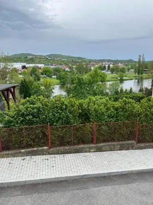 a fence on the side of a road with a river at Apartmán u Berounky in Beroun