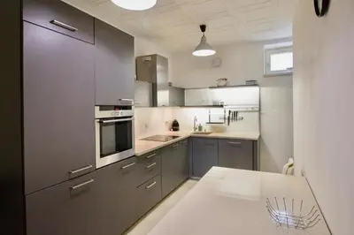 a kitchen with gray cabinets and a white counter top at Apartmán u Berounky in Beroun