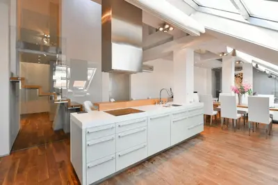 a kitchen with white cabinets and a dining room at LUXURY CENTRAL PENTHOUSE WITH SAUNA, TERRACE, 250m2, 5BDRM, 3BTHRM in Prague