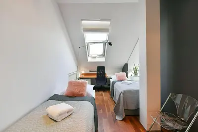 a attic room with two beds and a desk at LUXURY CENTRAL PENTHOUSE WITH SAUNA, TERRACE, 250m2, 5BDRM, 3BTHRM in Prague