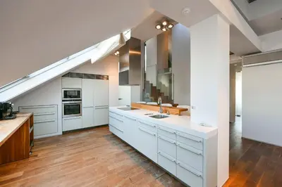 a large kitchen with white cabinets and a staircase at LUXURY CENTRAL PENTHOUSE WITH SAUNA, TERRACE, 250m2, 5BDRM, 3BTHRM in Prague