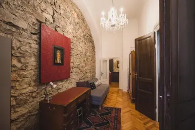 a living room with a stone wall and a chandelier at King Charles Apartment in Prague