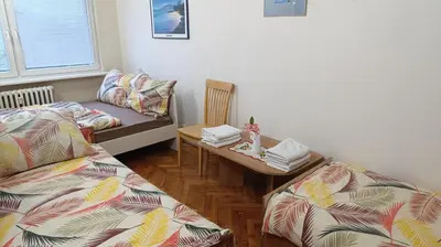 a room with two beds and a table and a couch at Apartment Dream in Prague
