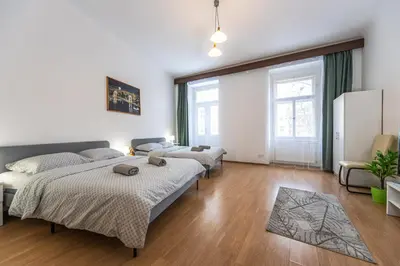 a bedroom with two beds and a couch at Wenceslas Square 2 Bedroom Apartment in Prague