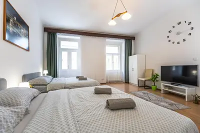 a living room with two beds and a flat screen tv at Wenceslas Square 2 Bedroom Apartment in Prague