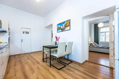 a kitchen and dining room with a table and chairs at Wenceslas Square 2 Bedroom Apartment in Prague