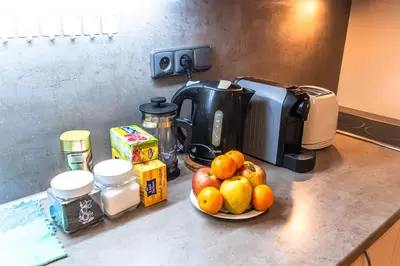 a bowl of fruit on a counter next to a coffee maker at Wenceslas Square 2 Bedroom Apartment in Prague