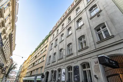 a large building with many windows on a city street at Wenceslas Square 2 Bedroom Apartment in Prague