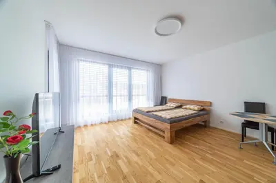 a white room with a bed and a table at Apartment Michelská in Prague