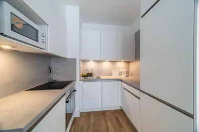 a white kitchen with white cabinets and a sink at Apartment Michelská in Prague