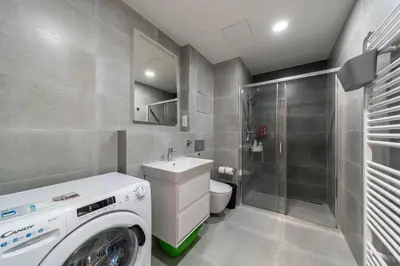 a bathroom with a washing machine and a sink at Apartment Michelská in Prague