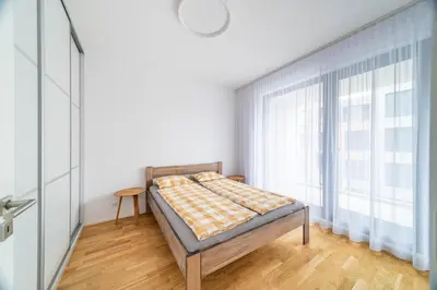 a bedroom with a bed and a large window at Apartment Michelská in Prague